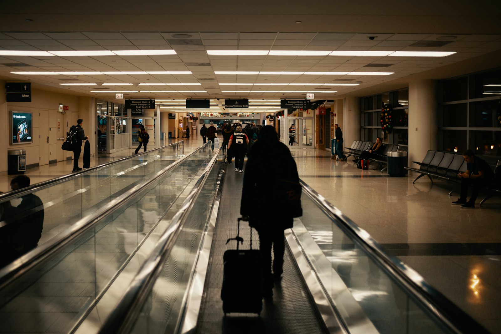 A traveler walking through an airport with luggage